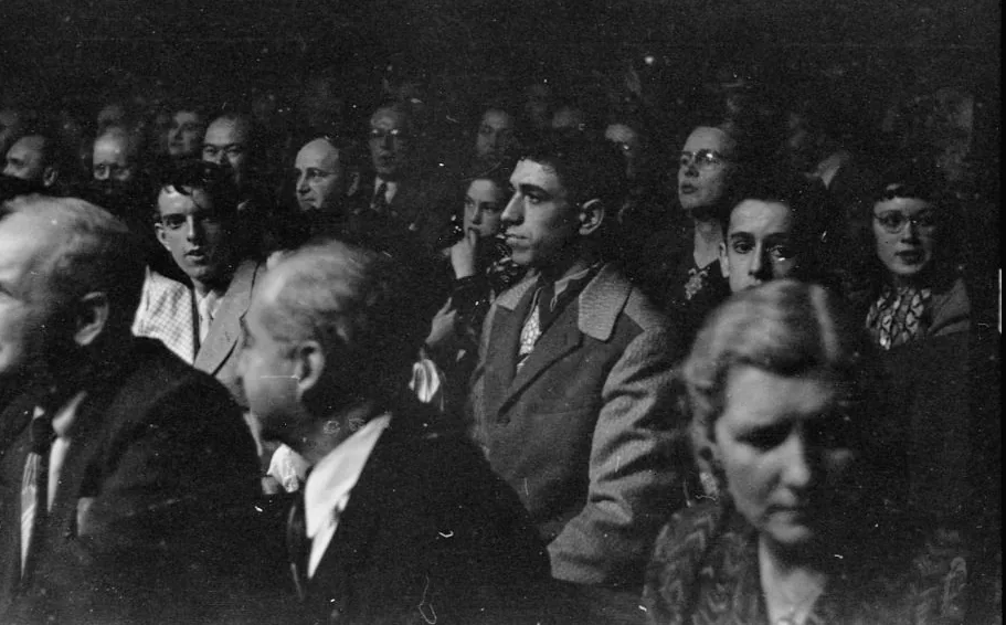 Fans packed into seats at a 1949 wrestling match, watching the ring intently