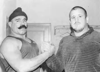 The Iron Sheik and Nikolai Volkoff shaking hands in a hallway in 1986