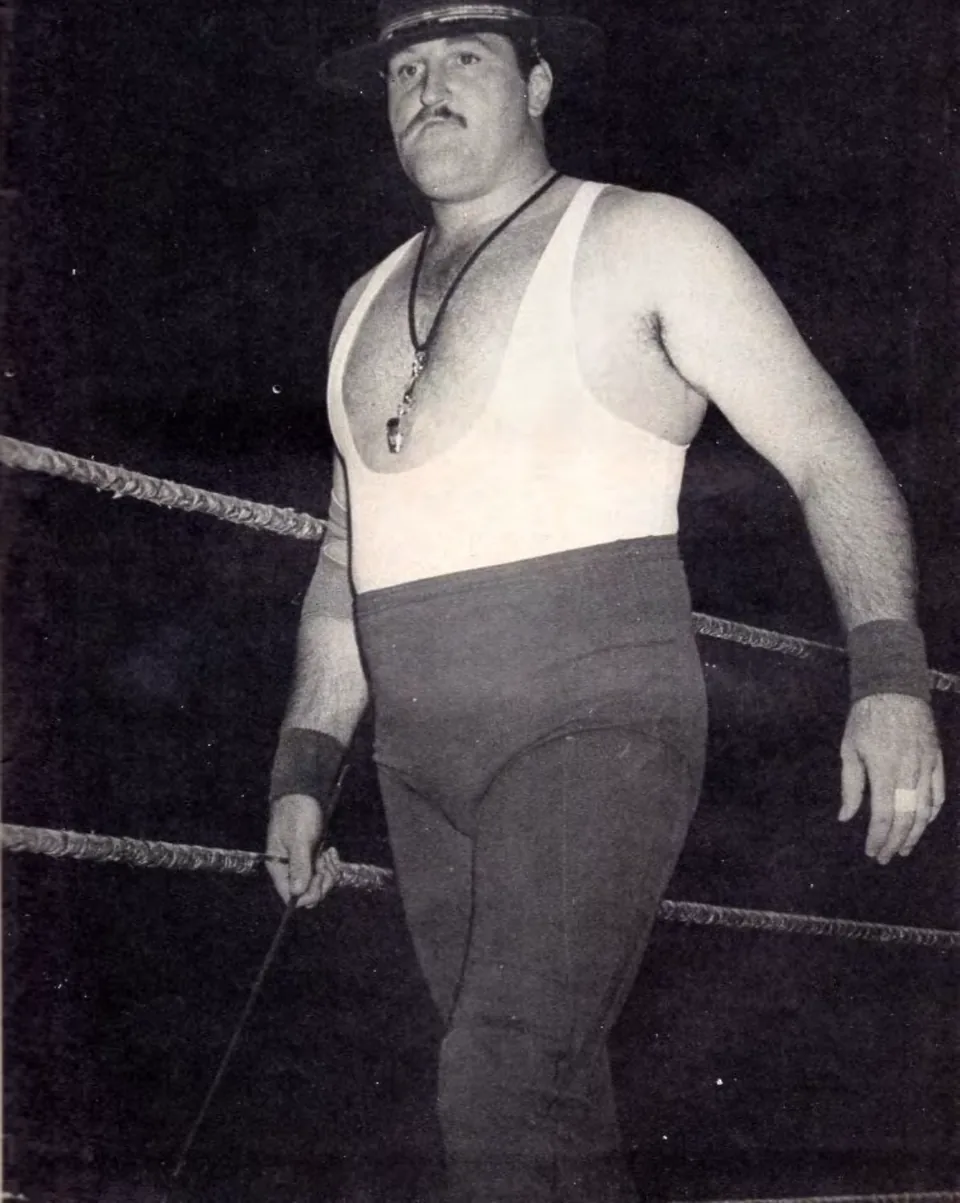 Sgt. Slaughter in 1984, in a campaign hat and white tank top, walking along the ring ropes