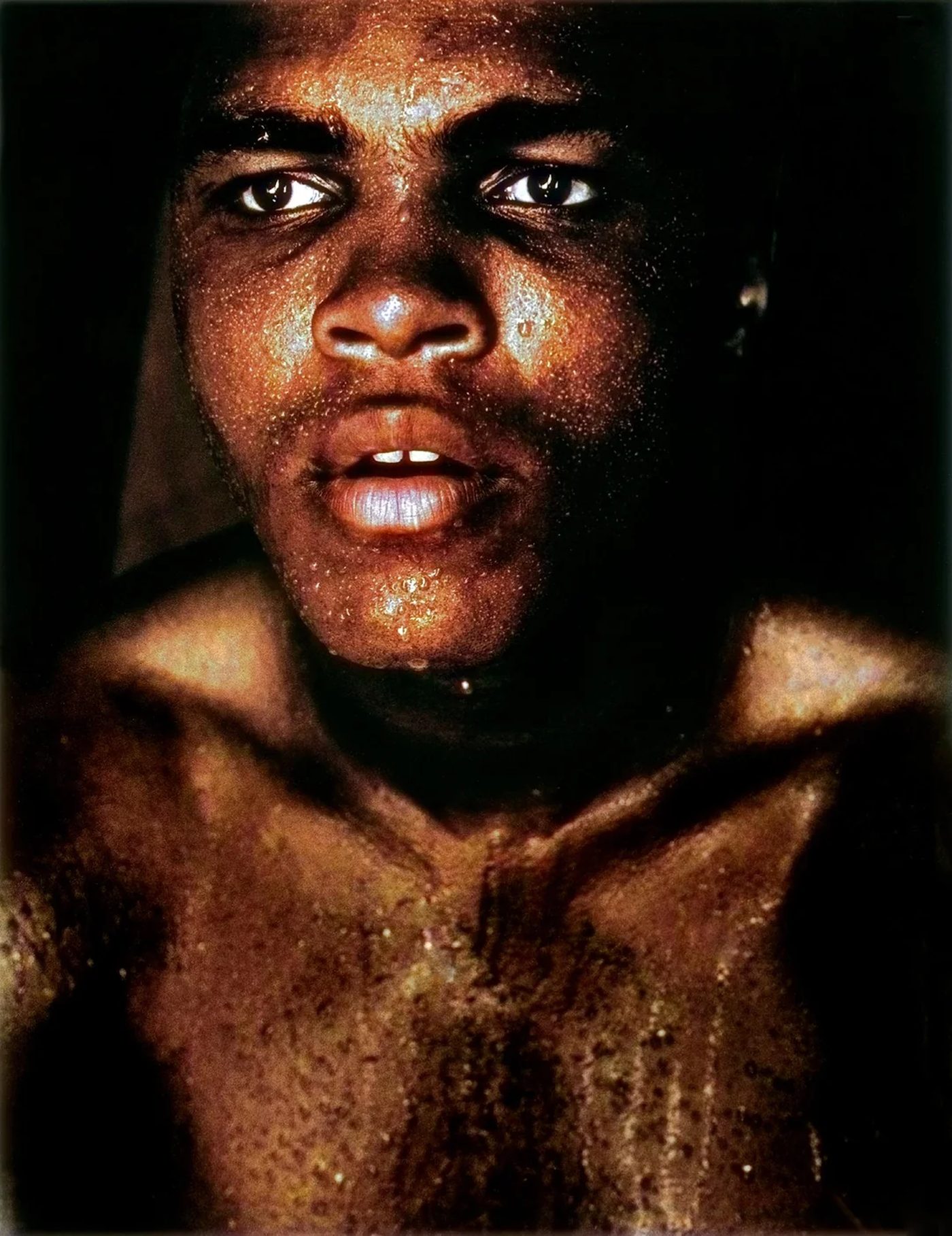 Muhammad Ali raising a gloved fist beside the words What’s My Name