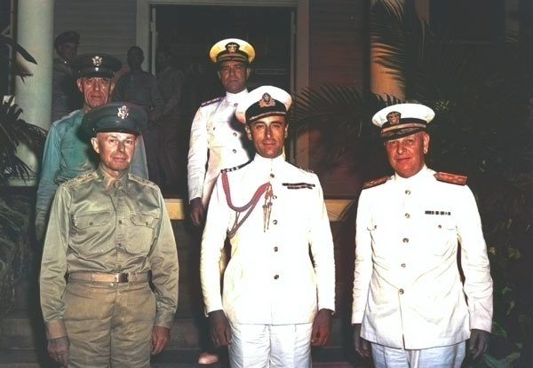 General Short in an Army uniform and Admiral Kimmel in Navy whites standing beside Lord Louis Mountbatten on a porch.