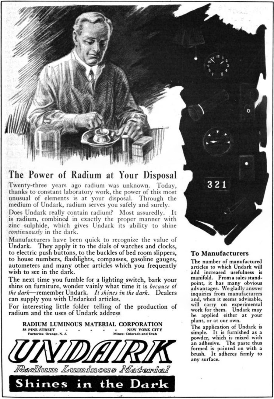 A 1921 magazine advertisement showing a man at a desk under a glowing clock, with the word UNDARK in large letters and the slogan Shines in the Dark.