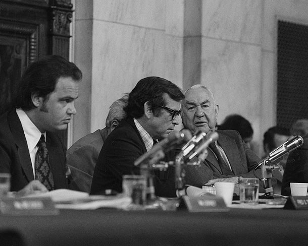 Three men in suits at a hearing table with microphones: Fred Thompson, Howard Baker and Sam Ervin.