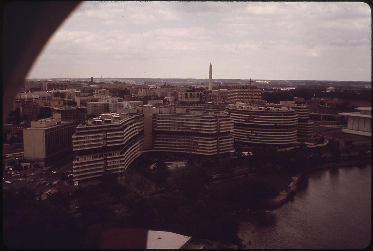 The curved Watergate complex beside the Potomac River with the Washington Monument in the distance.