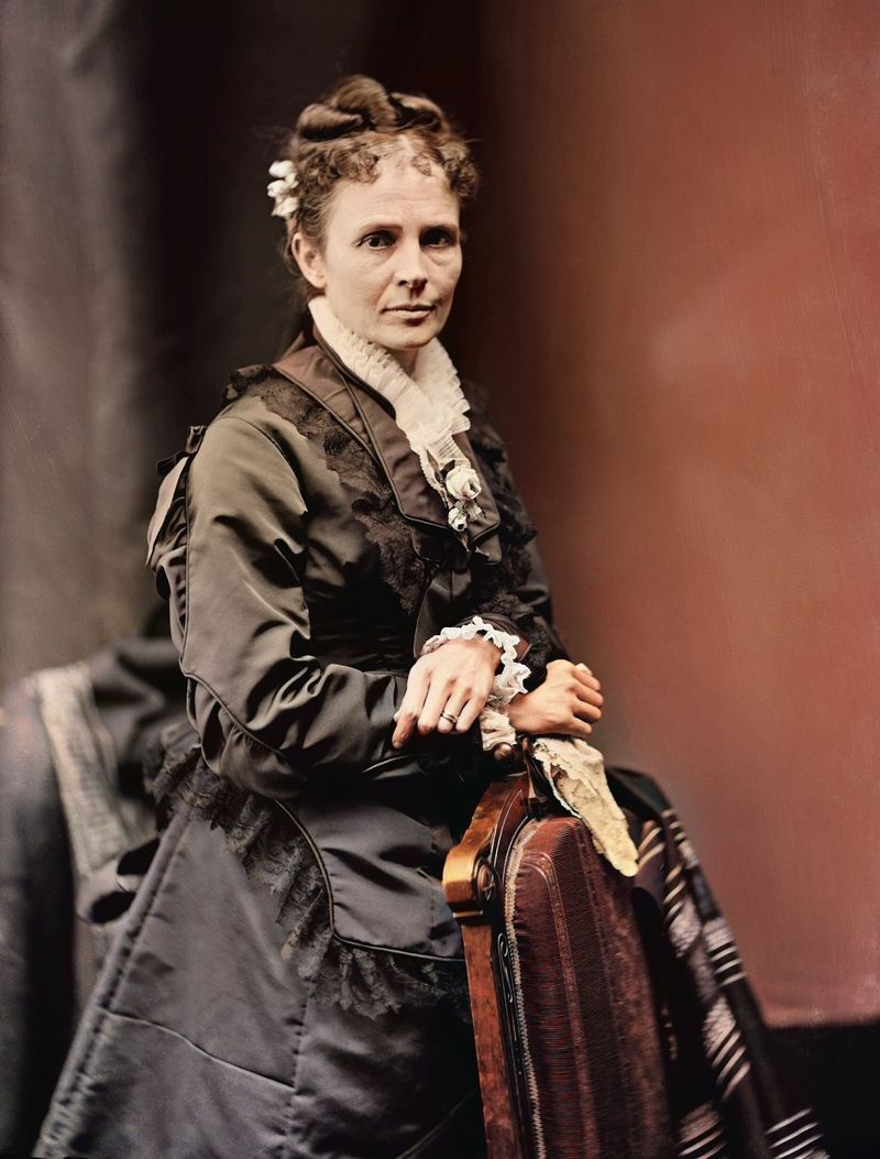 Colorized photograph of Lucretia Garfield standing beside a carved chair in a dark silk dress with a white lace collar