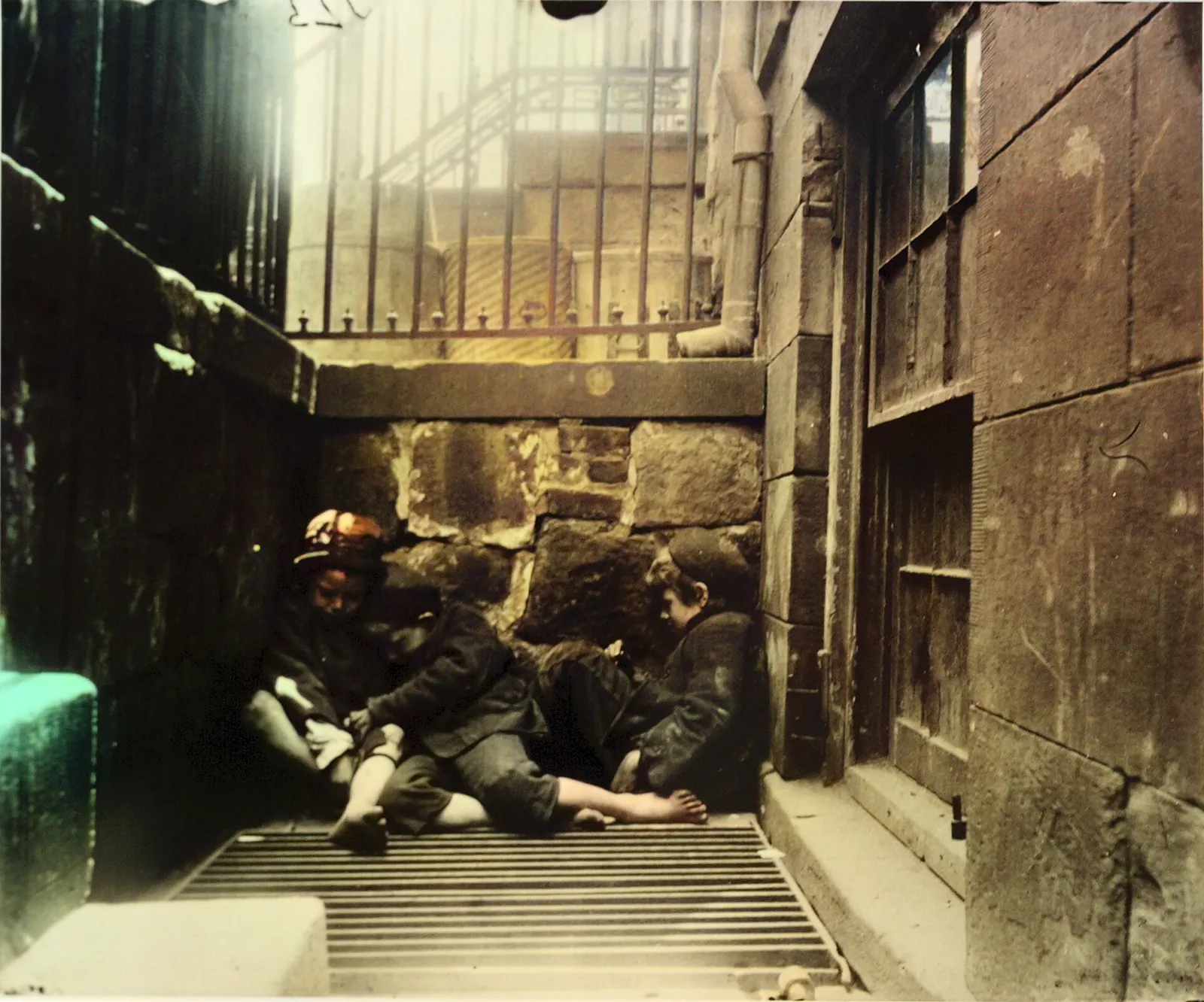 Jacob Riis photograph of boys asleep together in a narrow stone areaway