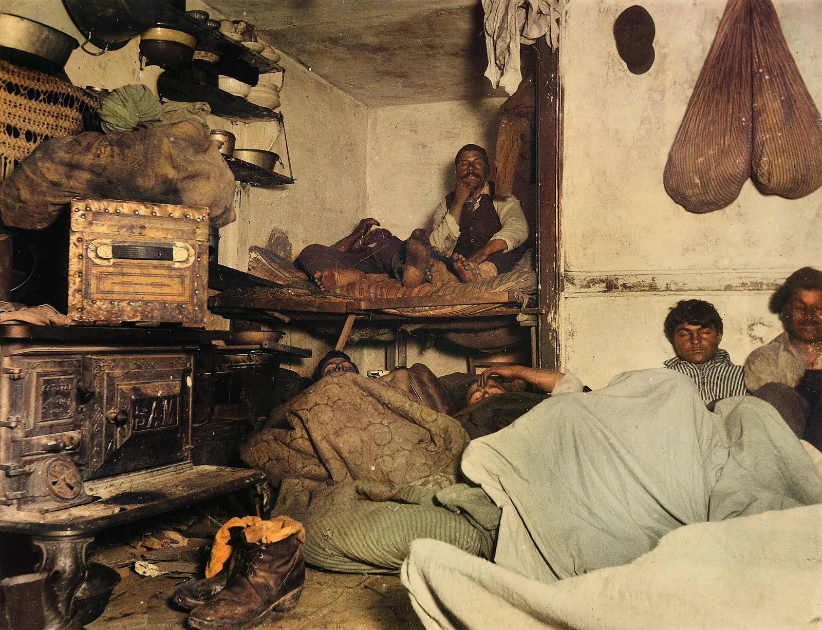 Jacob Riis photograph of lodgers lying on bunks and the floor of a crowded Bayard Street lodging room