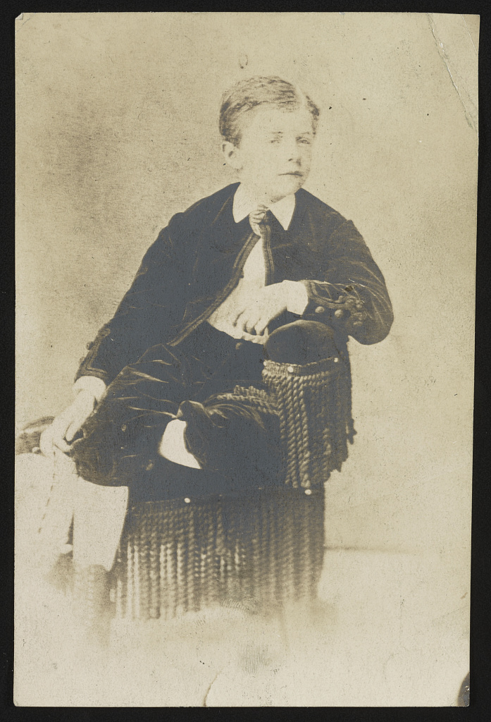 Theodore Roosevelt as a young child, seated in a chair.