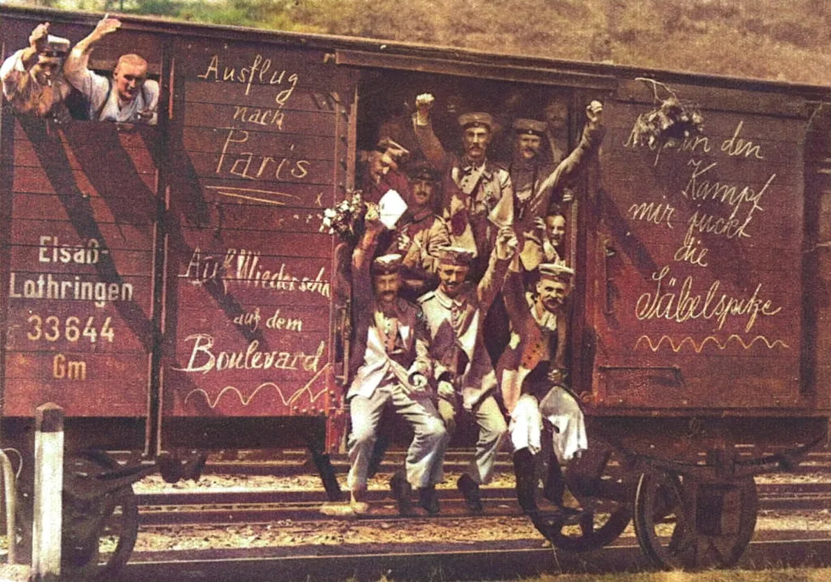 German soldiers waving from a rail car in 1914. Chalk on the car reads Ausflug nach Paris and Auf Wiedersehn auf dem Boulevard
