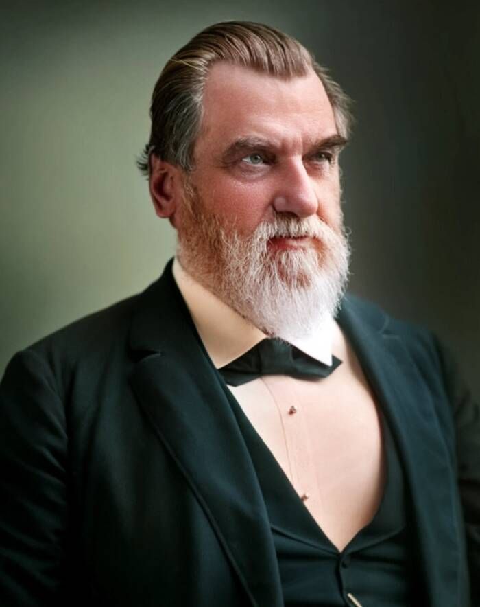 Portrait of Leland Stanford, a heavy set man with a gray beard in a dark suit.