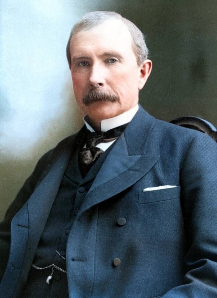 Portrait of John D. Rockefeller with a gray mustache in a dark suit.