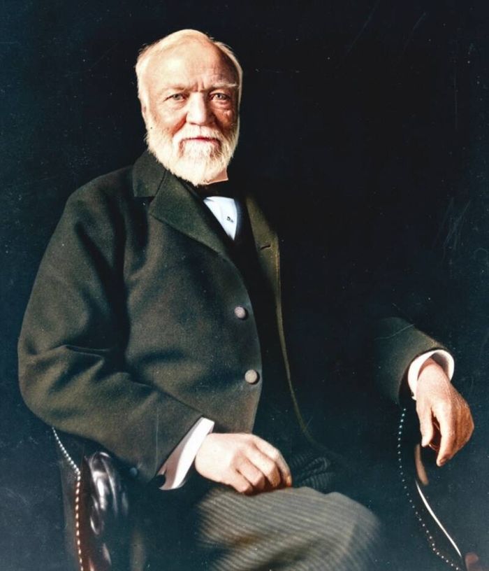 Portrait of Andrew Carnegie, a white bearded man seated in a dark suit.