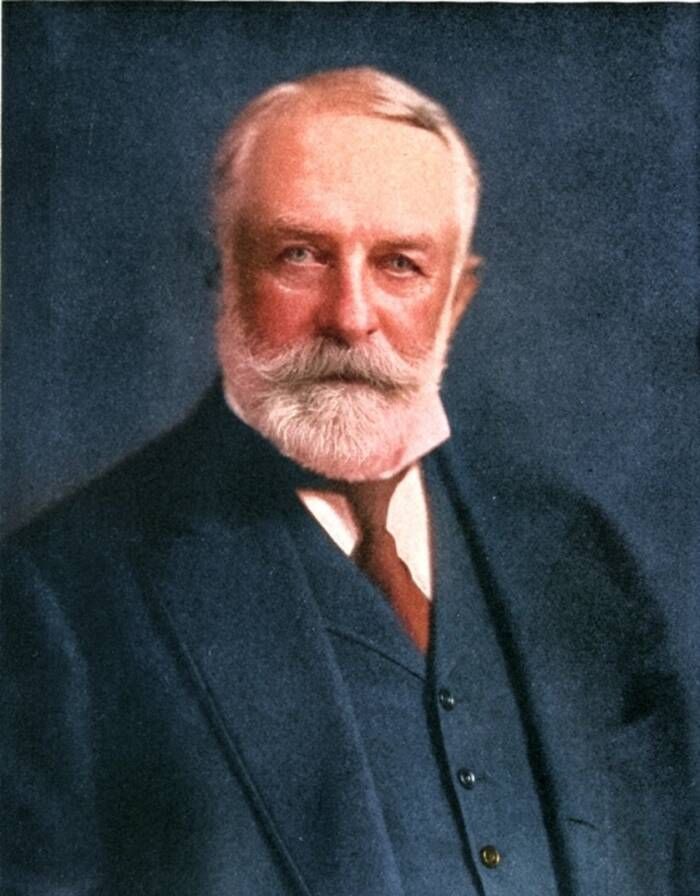 Portrait of Henry Clay Frick with a white beard in a dark suit and red tie.